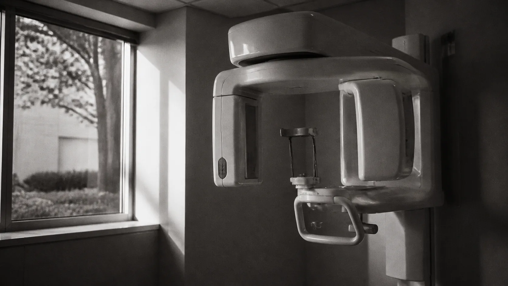 Illustrative cone beam scanner in a softly lit imaging room.